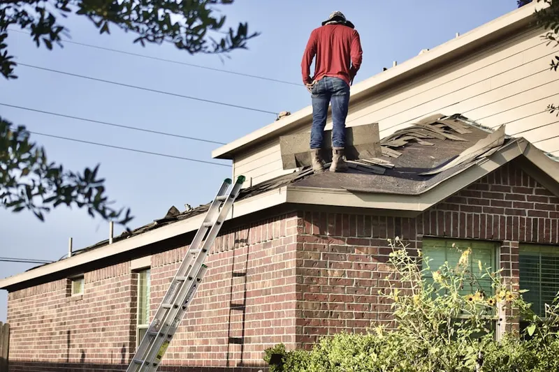 Professional roofer working on a residential roof in Halls